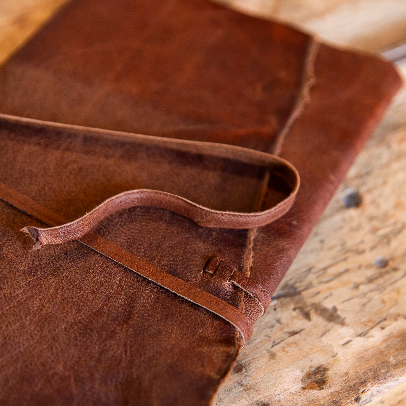 Close-up of leather wrap journal on a wooden surface