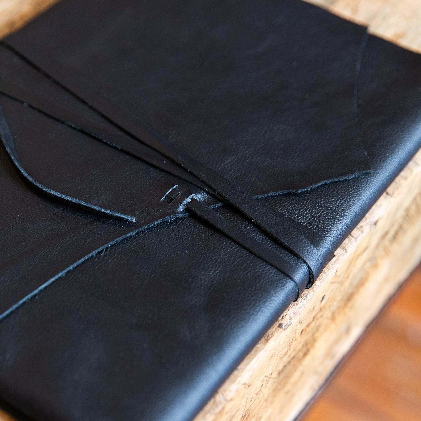 Black leather notebook on a wooden surface