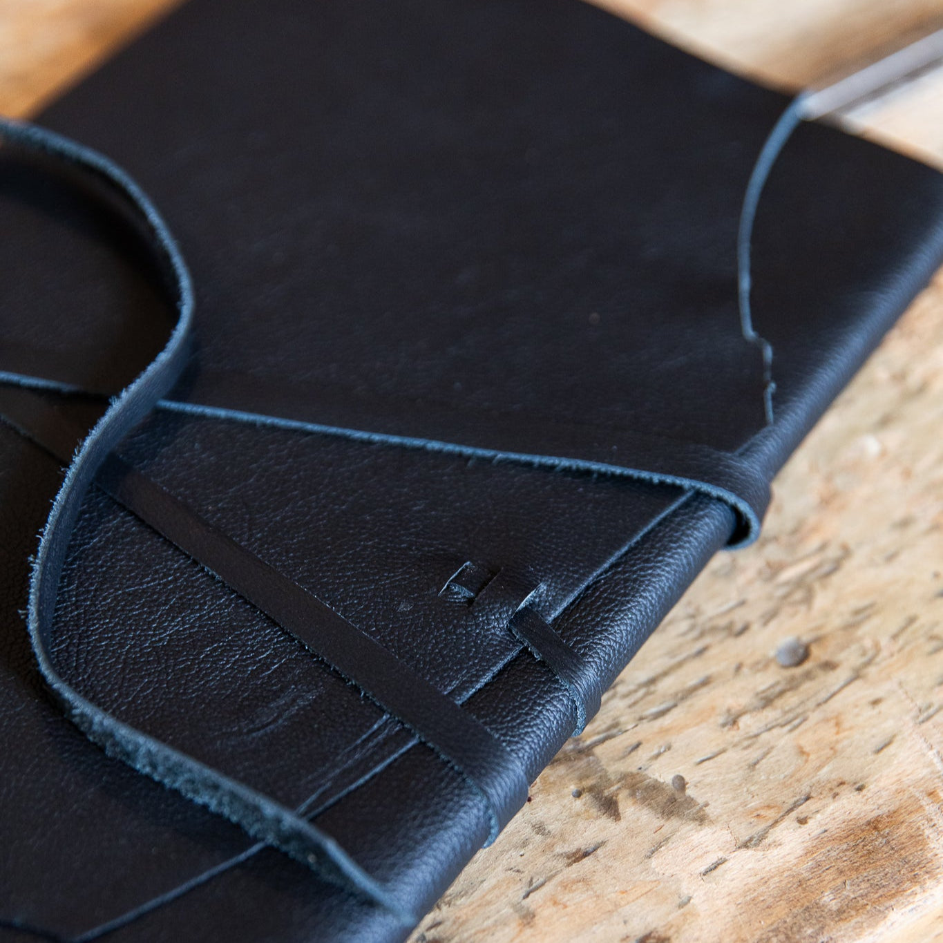 Black leather journal on a wooden surface