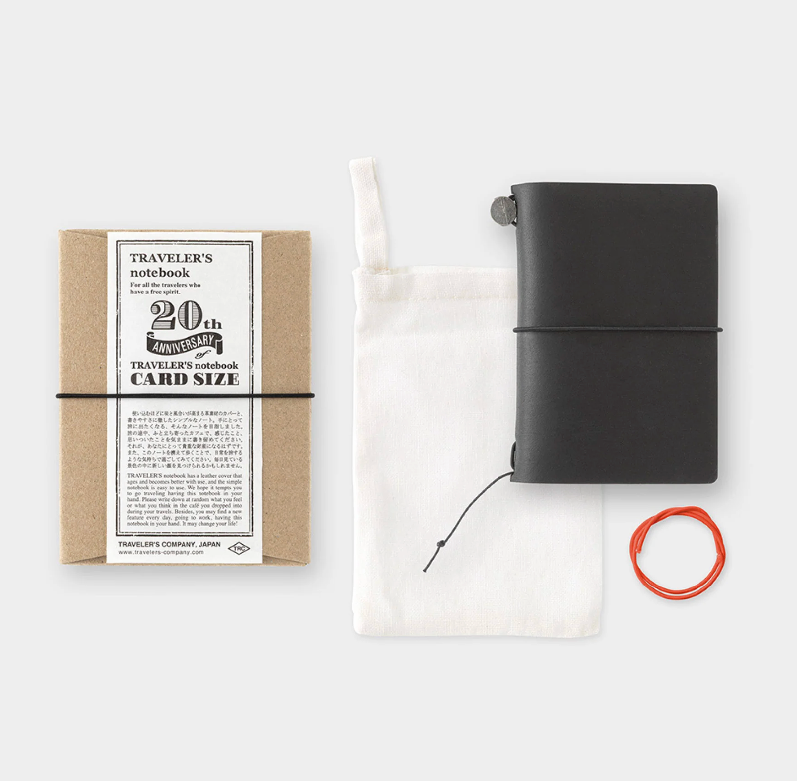 Black travel notebook with packaging and accessories on a white background
