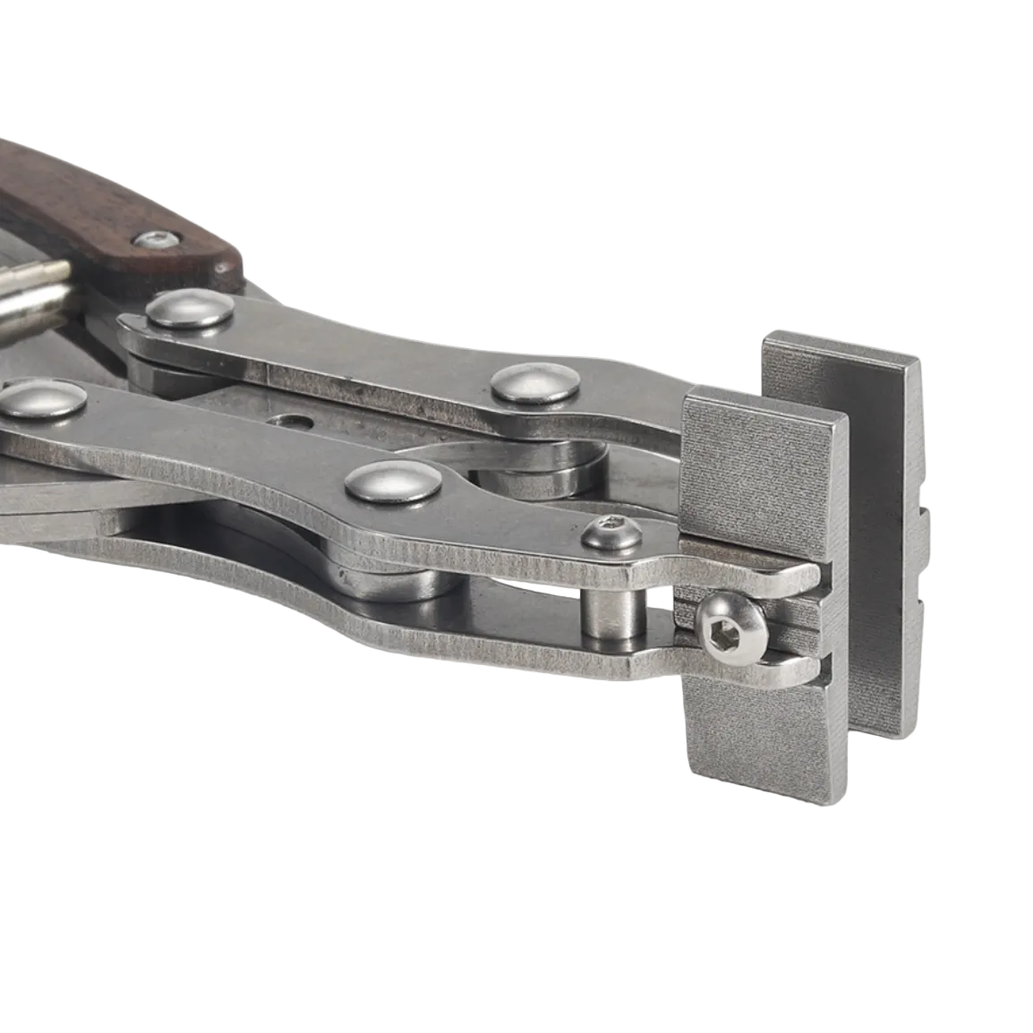 Close-up of a metal leather-tool pliers with silver-toned metal arms, rivets, and a dark brown wooden handle section, photographed on a light textured background.