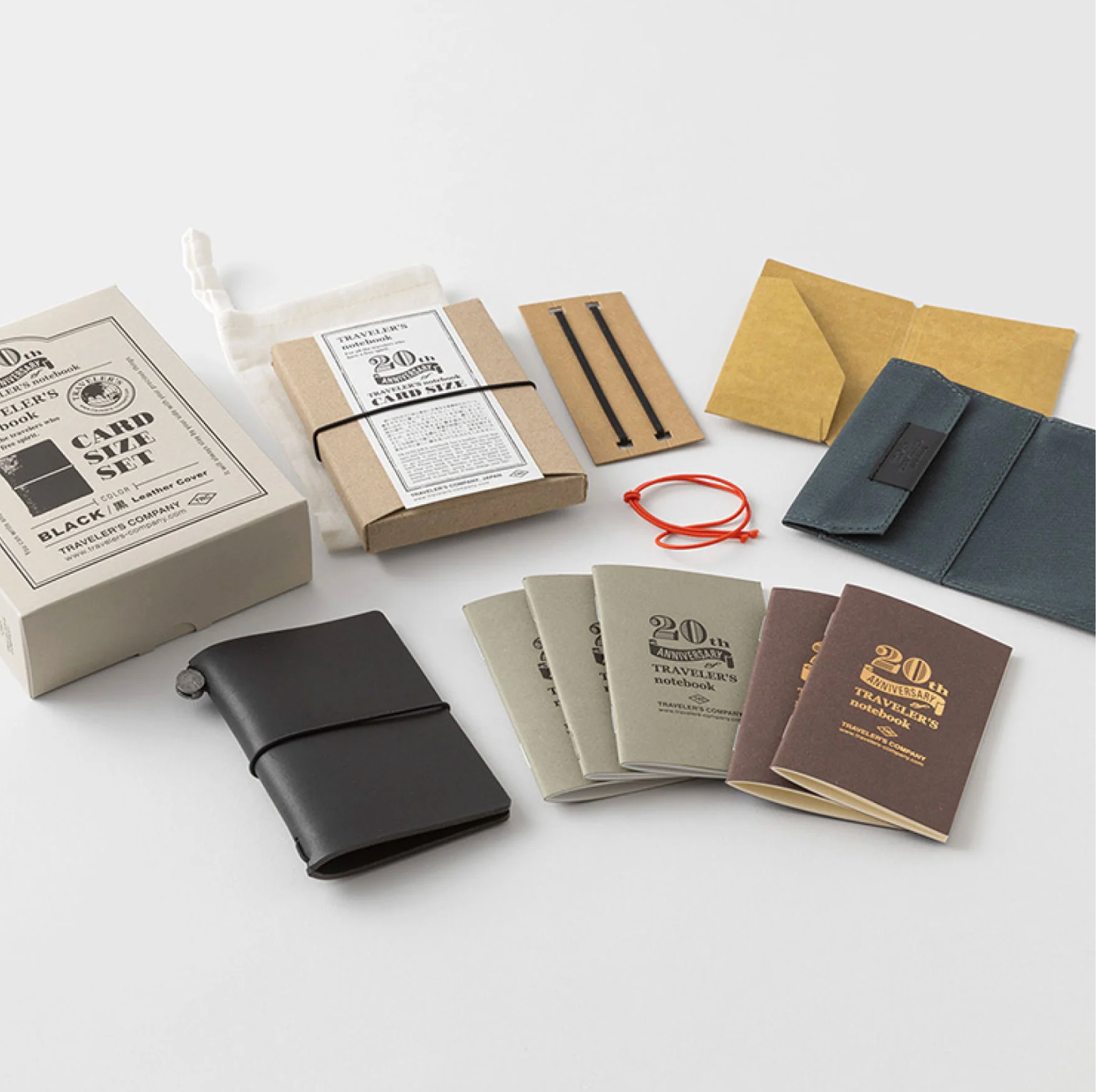Collection of notebooks, wallets, and stationery items on a white surface
