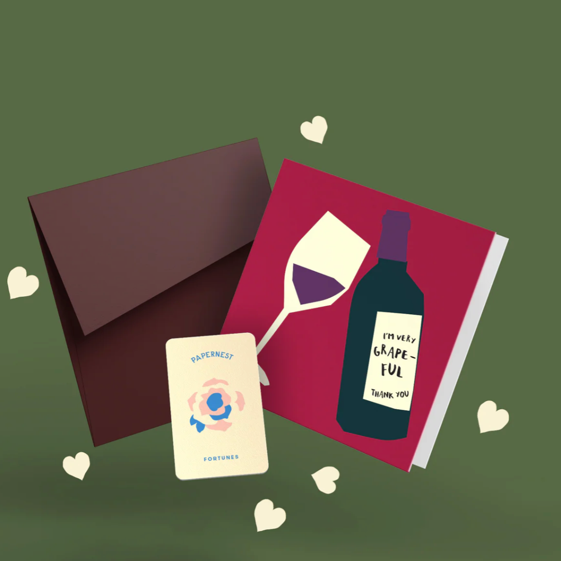 Greeting card with wine bottle and glass illustration, envelope, and small card on a green background