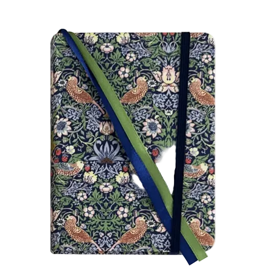 A hardcover notebook featuring a detailed William Morris-style floral and bird pattern in navy, green, beige, and brown, with a green and navy striped paper ribbon bookmark.