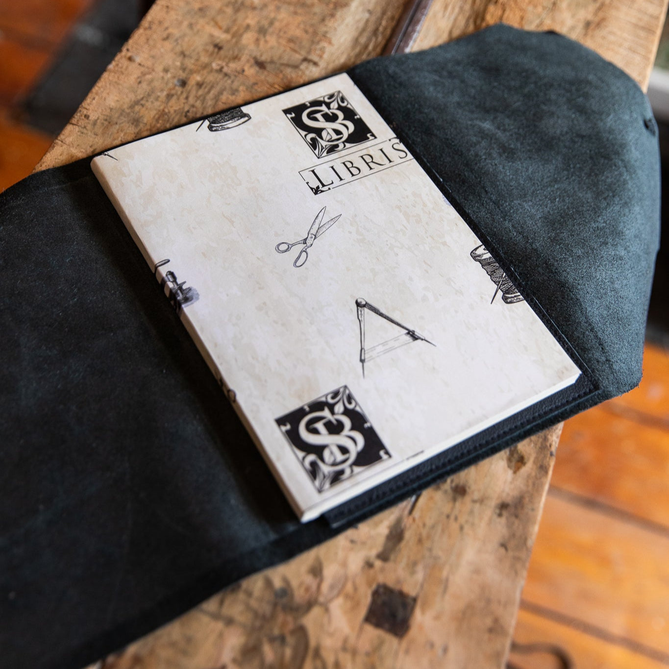 Leather wrap open with 'sb libris' refill on a wooden surface