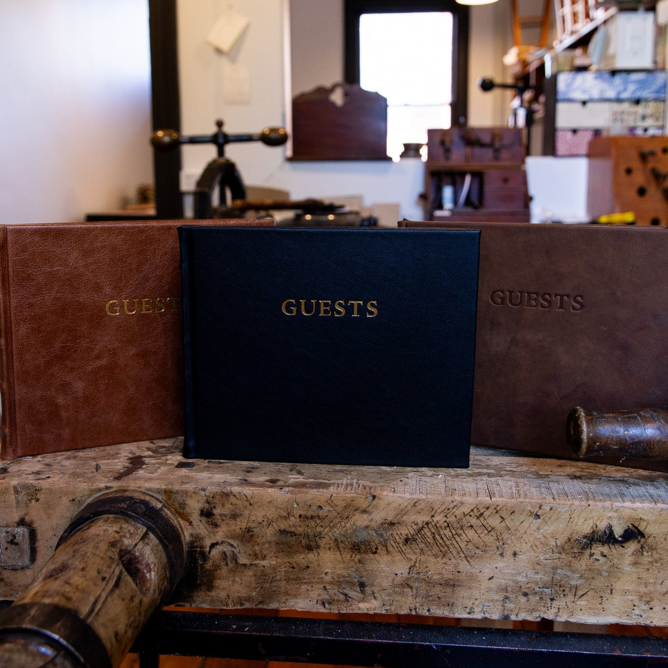 Three colours of large leather guest books with embossed guest on front cover.