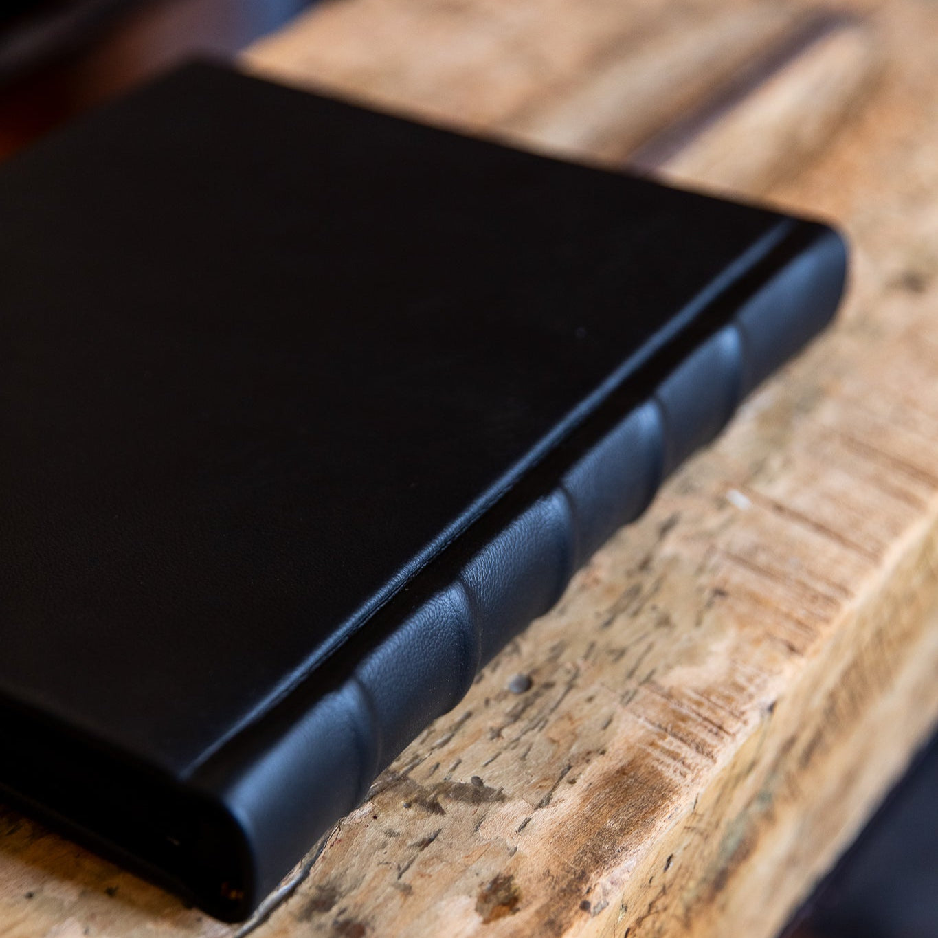 Black leather-bound album on a wooden surface