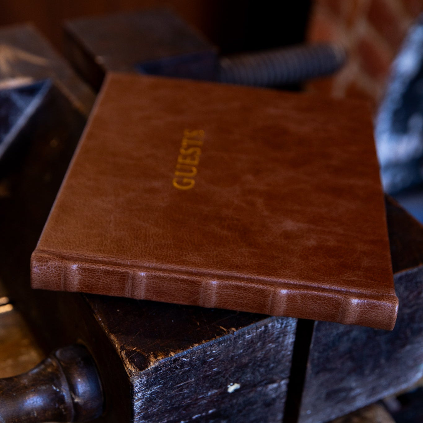 Brown leather guest book on a wooden surface with a blurred background