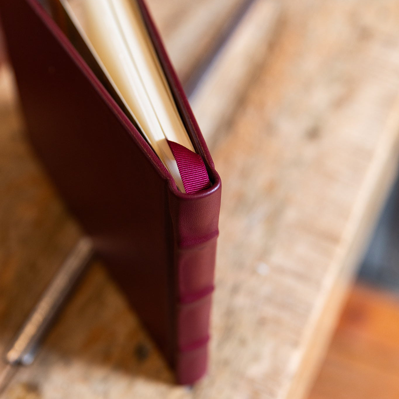 Close-up of a maroon leather-bound book on a wooden surface