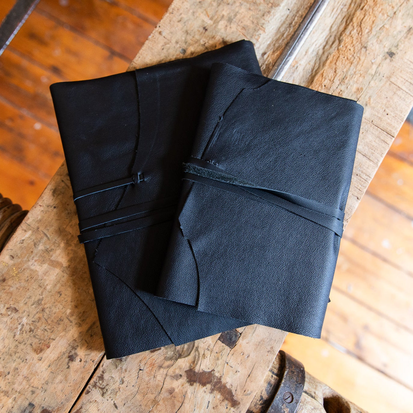 Black leather journals on a vintage timber laying press
