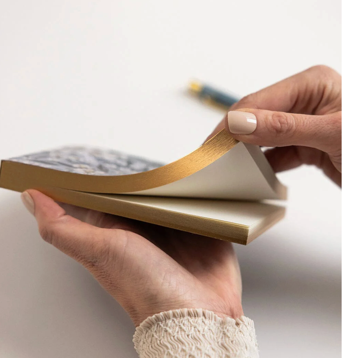 Person holding a stack of notebooks with a blurred background