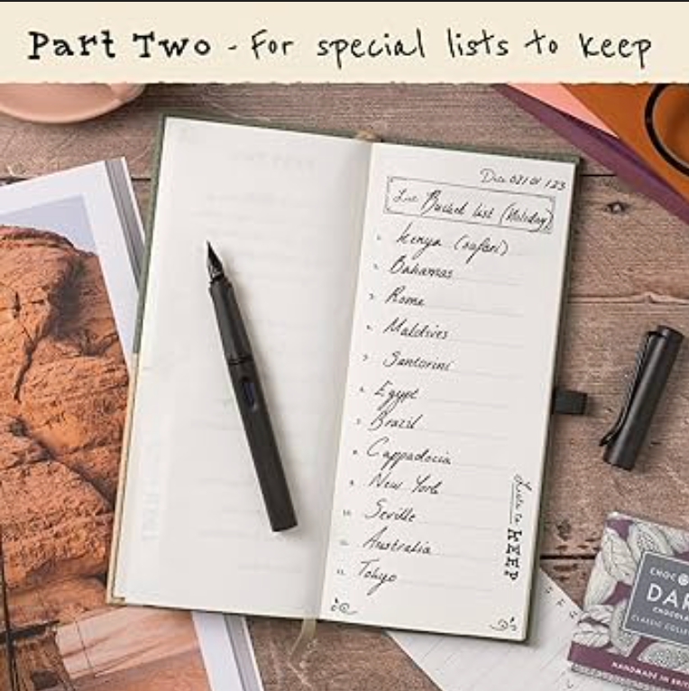 Open notebook with handwritten list on a wooden surface with a pen and travel-themed cards.