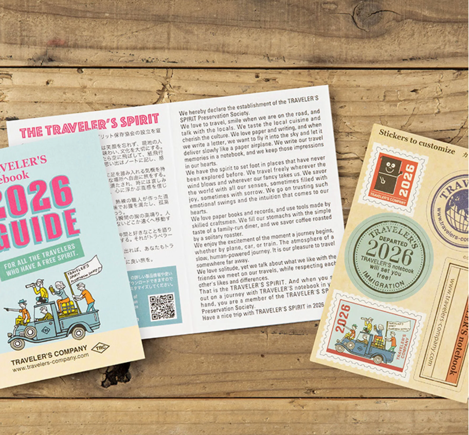 Traveler's Company 2026 guidebook and stickers on a wooden surface