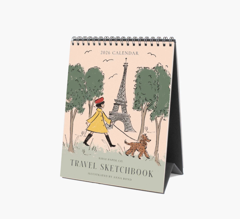 Desk calendar with illustration of a person walking a dog near the Eiffel Tower, titled 'Travel Sketchbook'.