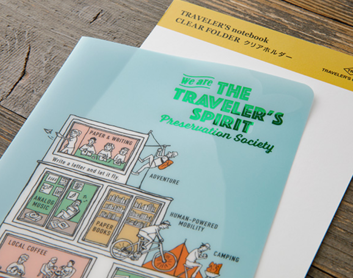 Traveler's notebook with colorful illustrations on a wooden surface