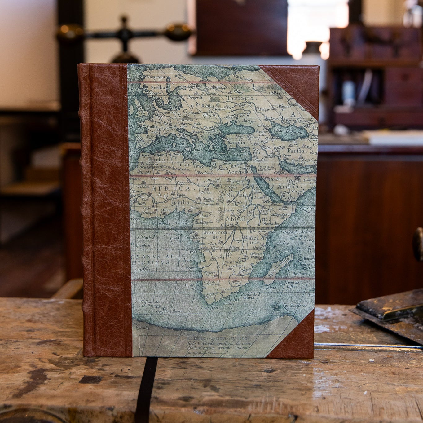 Front view of large half leather journal by SB Libris featuring a detailed vintage map design and brown goatskin leather.