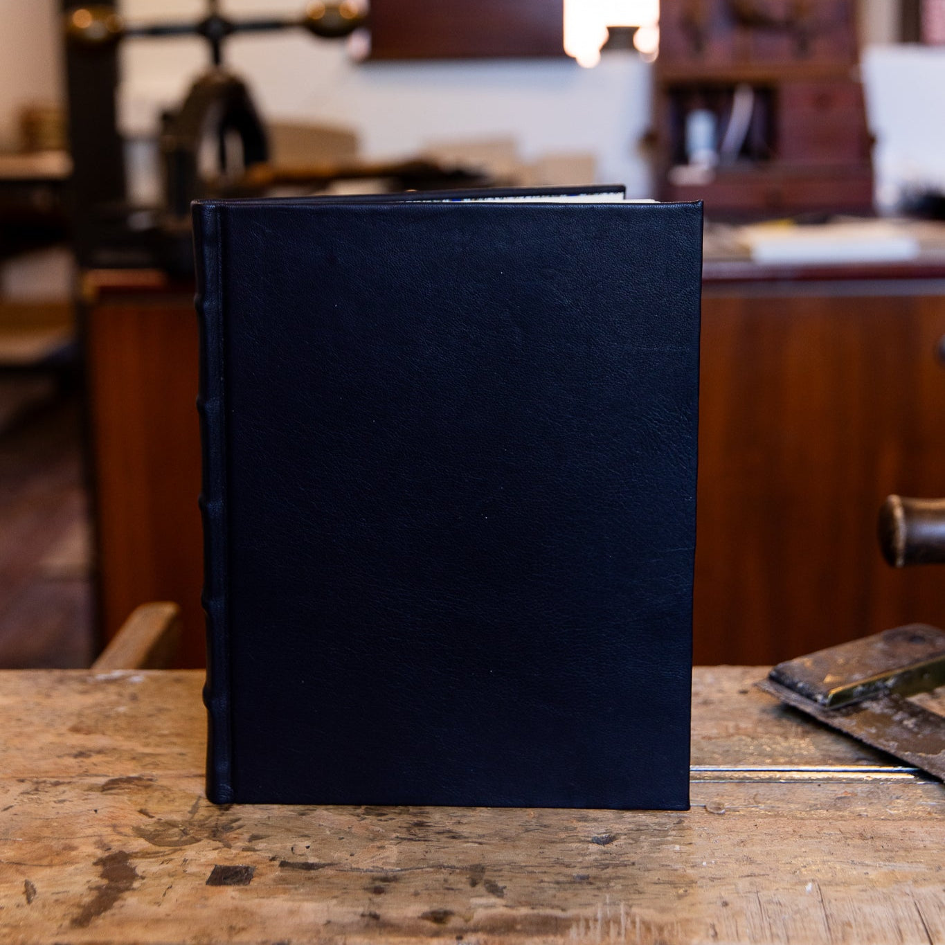 Front view of the large SB Libris Classic Journal in smooth black leather, standing upright with classic hand-crafted raised bands on the spine.