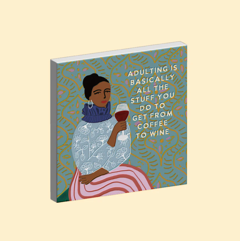 Ceramic magnet with illustration of a woman holding a glass of wine and text on a beige background