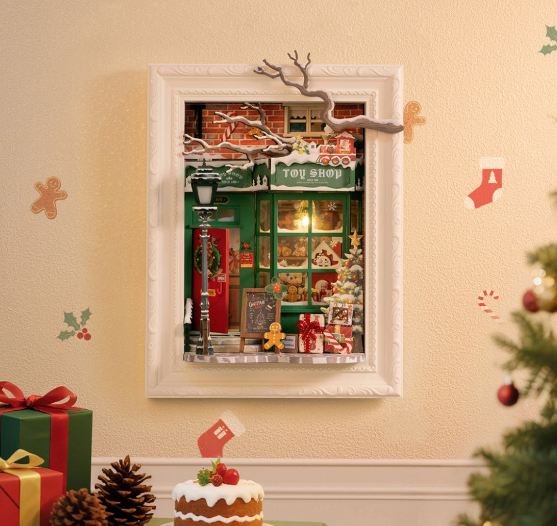 Decorative toy shop scene in a frame on a wall with Christmas decorations.