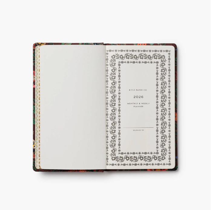 Open planner with decorative cover on a white background