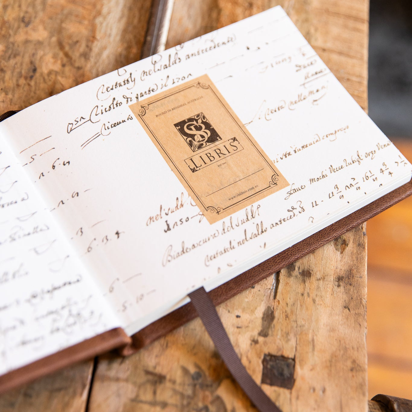 Open book with 'SB Libris' bookplate on a wooden surface