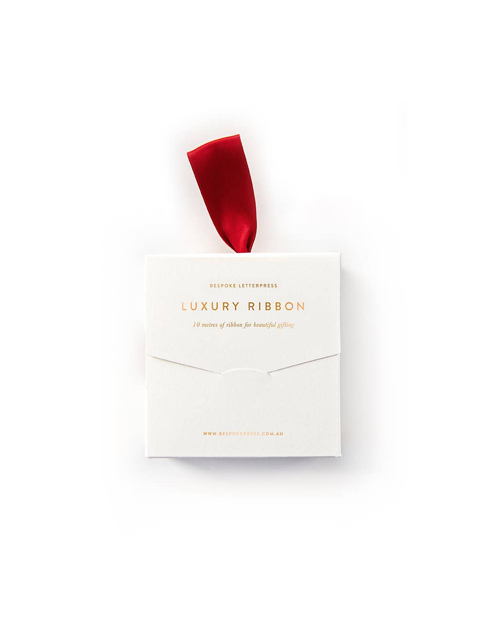 A spool of red luxury satin ribbon protruding from a gold foil printed box with the text 'LUXURY RIBBON' on it.