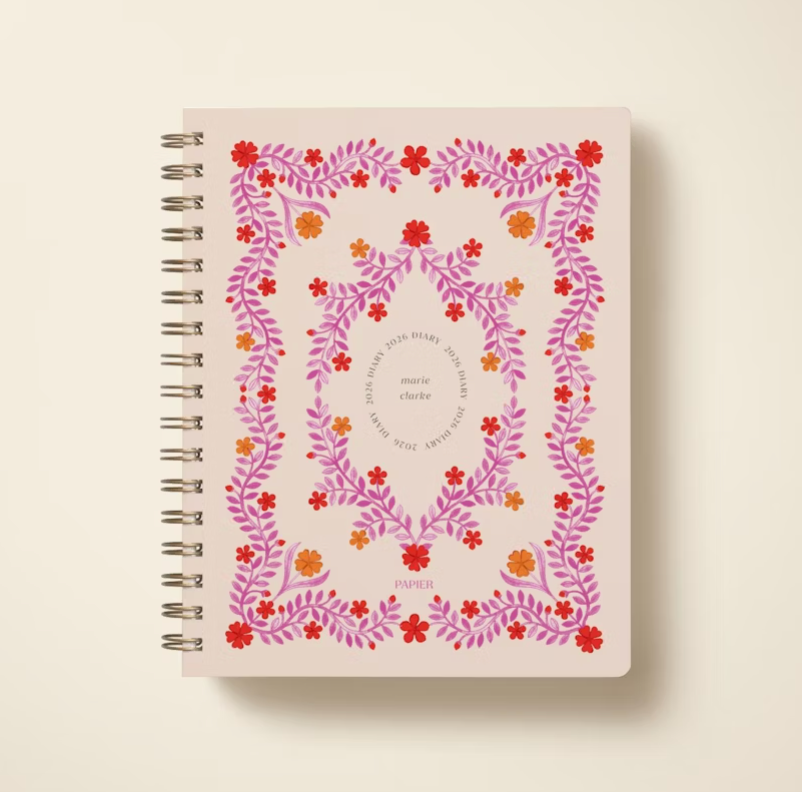 Notebook with floral design and text on a beige background