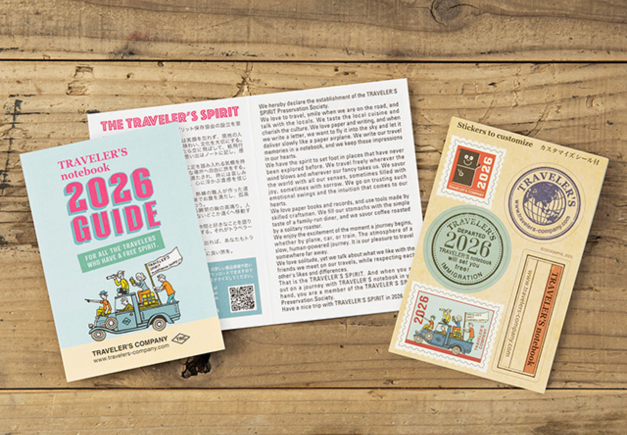 Traveler's Company 2026 Guidebook and related items on a wooden surface
