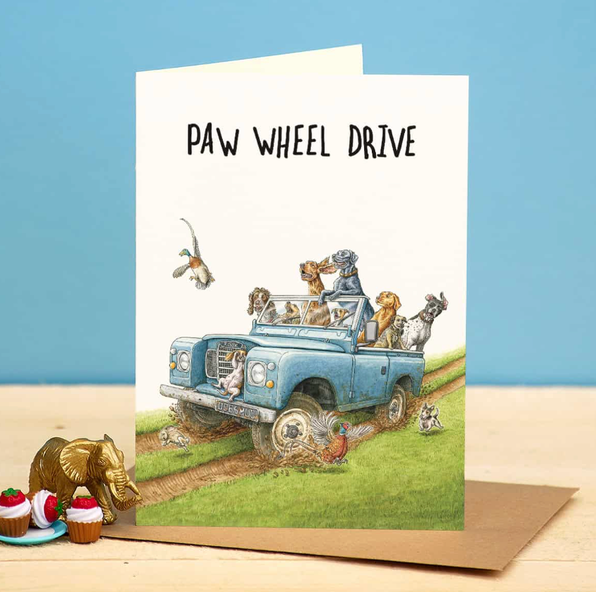 Card with illustration of a blue jeep with animals and text 'Paw Wheel Drive' on a blue background.