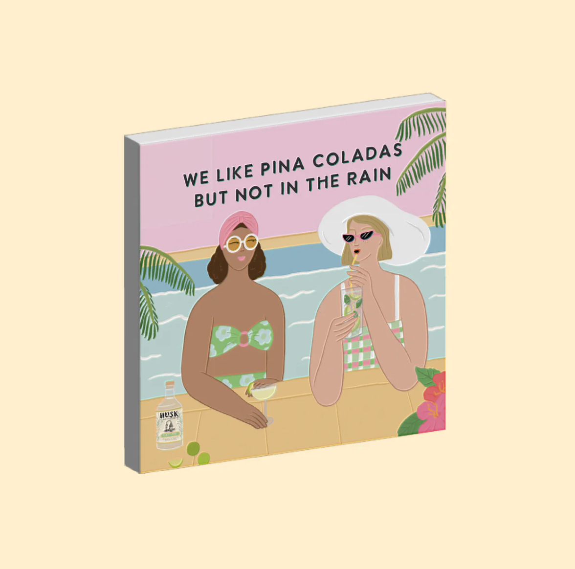 Magnet with illustration of two women at a beach, holding drinks with text 'We like pina coladas but not in the rain'.