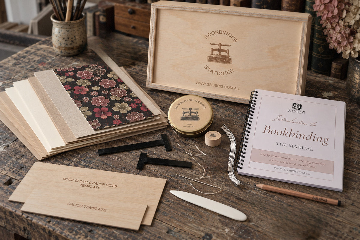 SB Libris Beginners Bookbinding Kit with plywood toolbox, manual, adhesive and tools on a bookbinder's desk