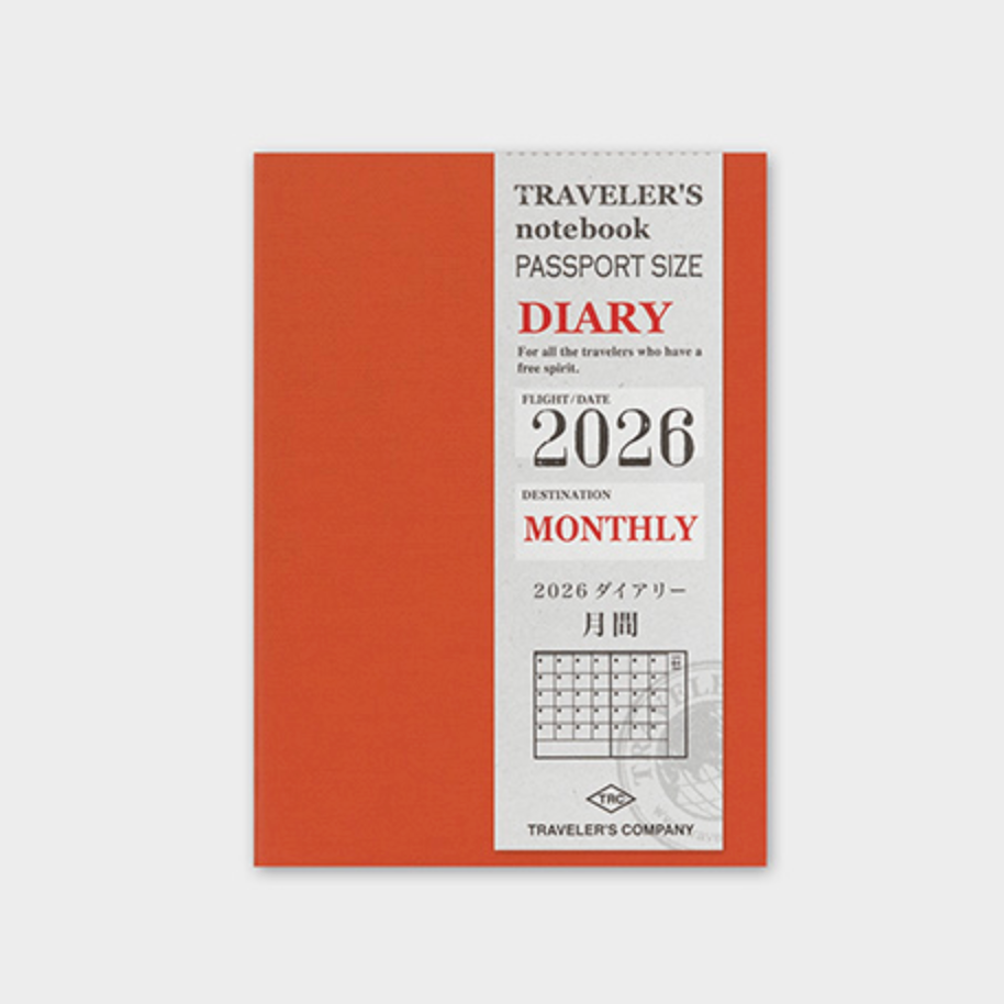 Traveler's notebook passport size diary with red cover and white label on a light gray background